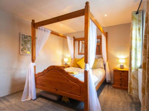 a bedroom with a wooden canopy bed with curtains at 1 Bed in New Moat oc-77692 in New Moat