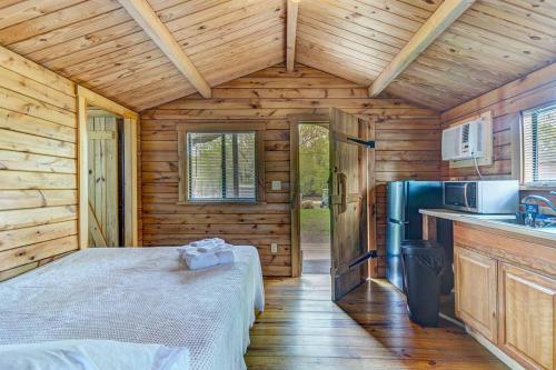 a bedroom in a wooden cabin with a bed and a refrigerator at Jellystone Park Gardiner in Gardiner