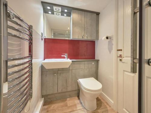 a bathroom with a white toilet and a sink at 8 Bed in Cumbria oc-sz373 in Applethwaite