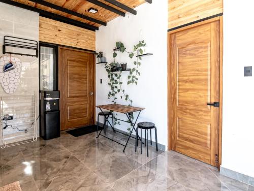 a kitchen with a wooden door and a table and stool at Casa Surf & Ola in San Felipe de Puerto Plata