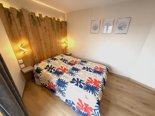 a small bedroom with a bed with a floral bedspread at Le Barral in Voiron