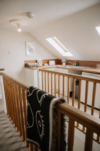 a room with a staircase with a kitchen and a sink at Room 2 at The Firs in Backwell