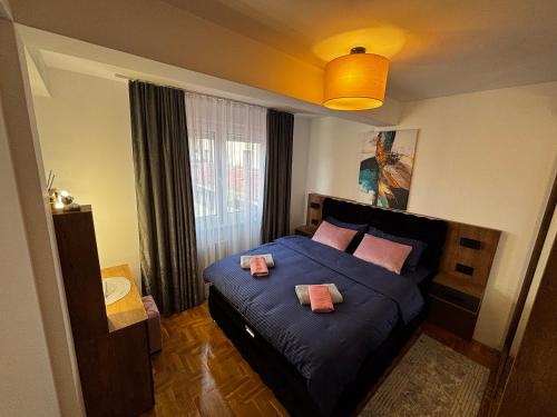 a bedroom with a bed with two pillows on it at Delux apartments in Gornji Milanovac