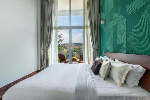 a bedroom with a large bed with a green wall at Vaga Valley in Vagamon