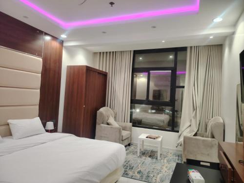 ein Hotelzimmer mit Bett, Schreibtisch und Stühlen in der Unterkunft ميلاف للشقق المخدومة Milaf For Serviced Apartments in Al Shafa