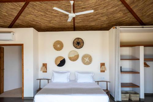 a bedroom with a bed with a ceiling fan at Adouna Bay in Cap Skirring