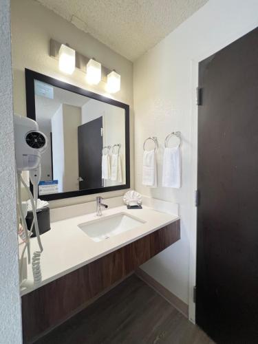 a bathroom with a sink and a large mirror at Sleep Inn Arlington Near Six Flags in Arlington