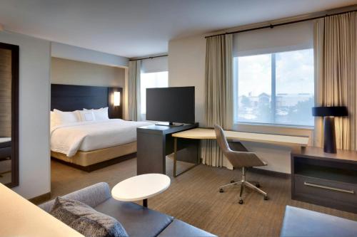 a hotel room with a bed and a desk with a computer at Residence Inn by Marriott Claremont in Claremont