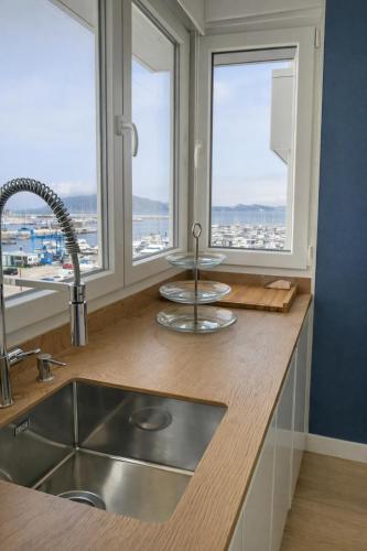 a kitchen with a sink and two windows at La Bahía in Baiona