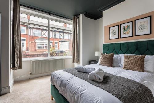 a bedroom with a large bed with a green headboard at 3 Bedroom House By Cozy Quarters Property Management Contractors Accommodation Seaham Near Sea in Seaham