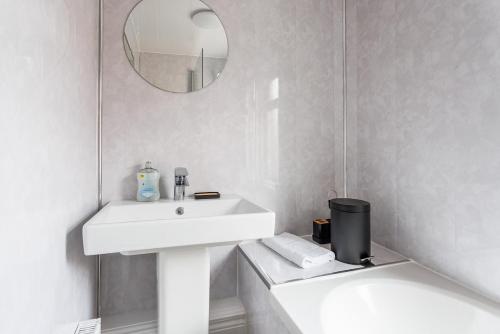a white bathroom with a sink and a mirror at 3 Bedroom House By Cozy Quarters Property Management Contractors Accommodation Seaham Near Sea in Seaham