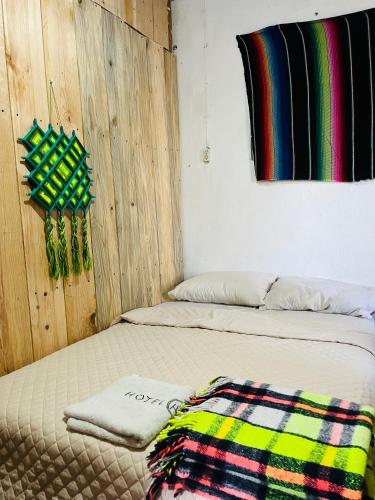a bed with a blanket on it in a room at Casa 74 hostel in Comitán