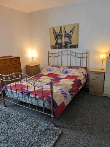 a bedroom with a bed and two dressers and two lamps at Kettering 4 night min stay with Shared Bathroom, lounge TV & kitchen free WIFI Genius on longer regular stays Professional workers Rooms in Kettering