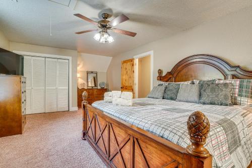 a bedroom with a wooden bed and a ceiling fan at Luxe Helen Gem w/Hot Tub + Pool Access in Helen