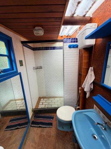 a bathroom with a shower and a toilet and a sink at Chales Bamboo Jungle in Petrópolis