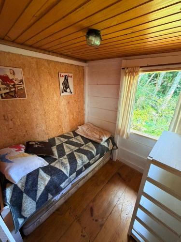 a small bed in a room with a window at Chales Bamboo Jungle in Petrópolis