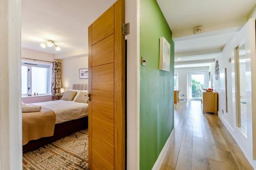 a bedroom with green walls and a bed and a door at 2 Bed in Keswick oc-28377 in Braithwaite