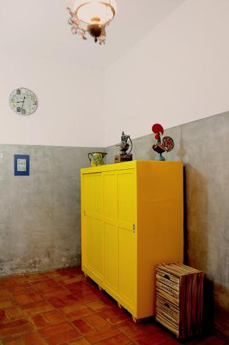 a yellow cabinet in the corner of a room at Casa da Avó Nina in Fuzeta