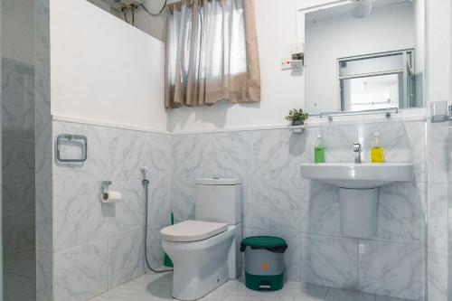 a bathroom with a toilet and a sink and a mirror at Edelweiss Resort in Mirissa