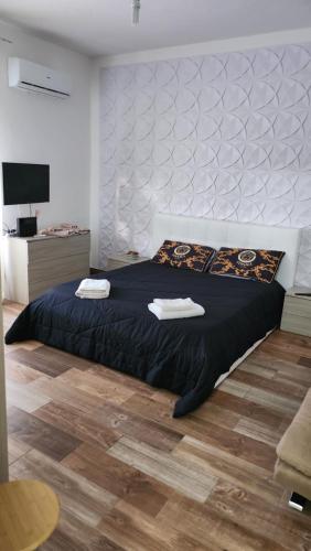 a bedroom with a large bed with two towels on it at La Terrazza di Rovaglioso in Palmi