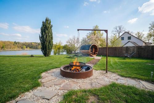 a fire pit in a yard next to a lake at Bezdrevská Bašta in České Budějovice