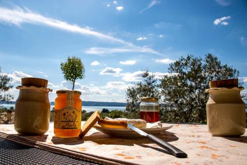 a table with jars of honey and a plate of bread at Agriturismo Parco di Canuleio - con vista sul Lago in Bolsena