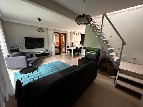 a living room with a couch and a staircase at Domek nad jeziorem Kamionki Małe in Kamionki Małe