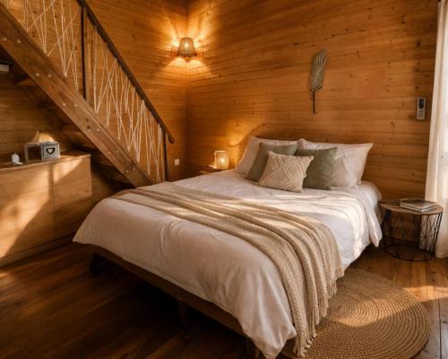 a bedroom with a bed in a wooden cabin at Bunga-lodge VANILLE in Saint-André