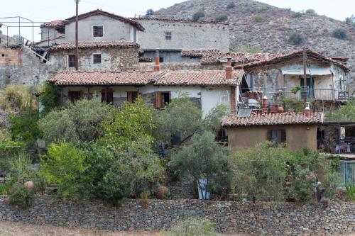 a group of houses with trees and a stone wall at Hatzikyprianou Museum Studio in Lazania