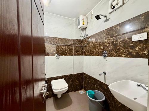 a bathroom with a toilet and a sink at Hotel Sai in Udupi