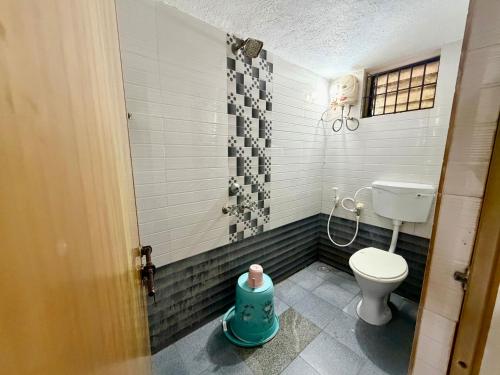 a bathroom with a toilet and a shower at Nanasu Home stay in Malpe
