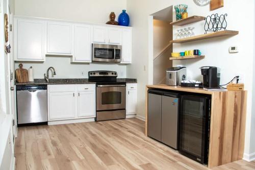 a kitchen with white cabinets and stainless steel appliances at True North - A Beach & Boat Lover's Dream in Carolina Beach
