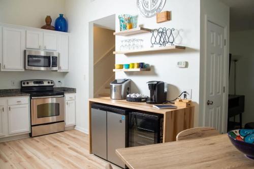a kitchen with white cabinets and a wooden counter top at True North - A Beach & Boat Lover's Dream in Carolina Beach