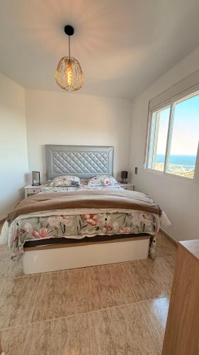 a bedroom with a bed and a chandelier at Peniscola Bella in Peniscola