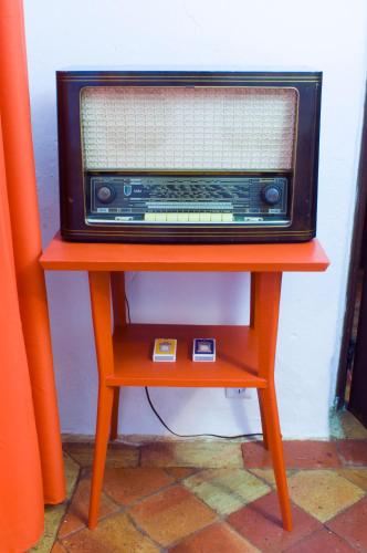 an orange table with a radio on top of it at Casa da Avó Nina in Fuzeta