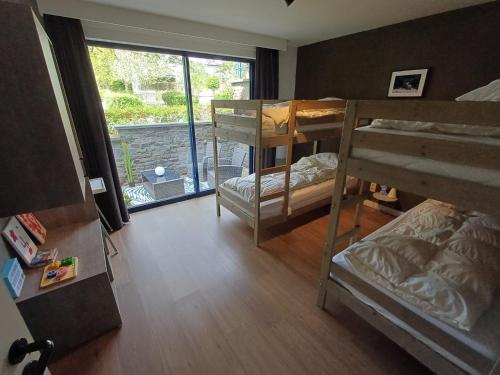 a dorm room with bunk beds and a large window at DURBUY au "trois marcassins" in Durbuy