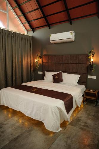 a bedroom with a large bed in a room at Wanderlust Villas in Pinangode
