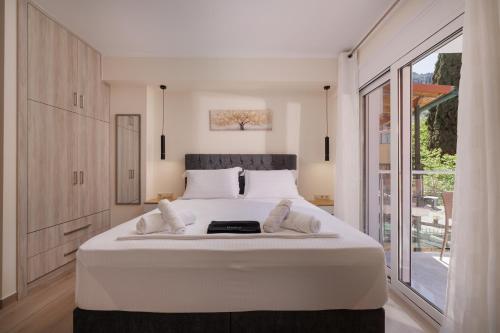 ein großes weißes Bett in einem Zimmer mit einem großen Fenster in der Unterkunft Plaka Studios 3 in Benitses