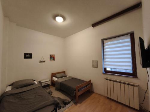 a bedroom with two beds and a window at Hideout apartments Travnik in Travnik