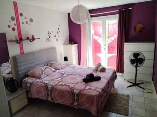 a bedroom with a bed with a pink comforter at Villa Luberon Piscine Pétanques in Cavaillon