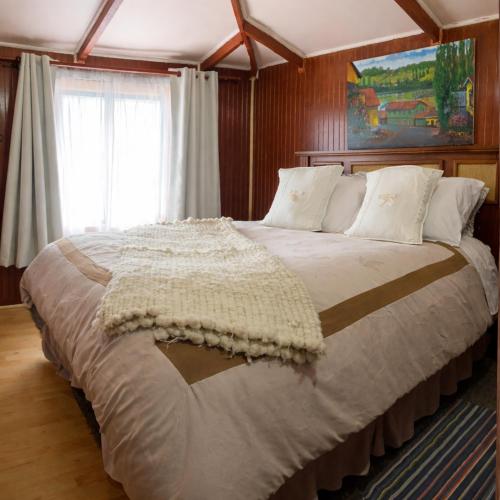 a bedroom with a large bed in a room at Hostal Art Gallery Chiloè in Castro