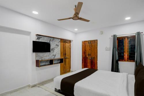 a bedroom with a bed and a ceiling fan at Super Hotel O iva Holiday inn in Maula Ali