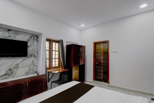 a bedroom with a bed and a tv on the wall at Super Hotel O iva Holiday inn in Maula Ali