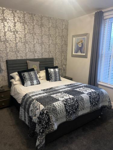 a bedroom with a bed with a black and white comforter at Fox lodge in Blackpool