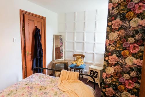 a teddy bear sitting in a chair in a bedroom at Motcombe Cottage in Hatherleigh