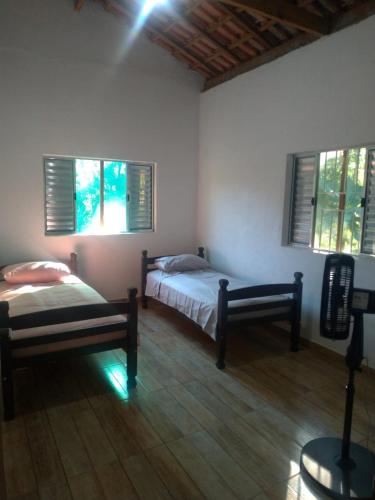 a bedroom with two beds and two windows at Bella Serra in Iporanga