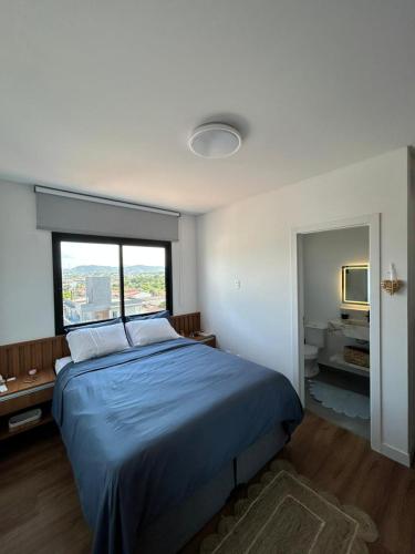 a bedroom with a blue bed and a window at Apê completo 2 quartos 300m da praia15min Beto Carreiro in Piçarras
