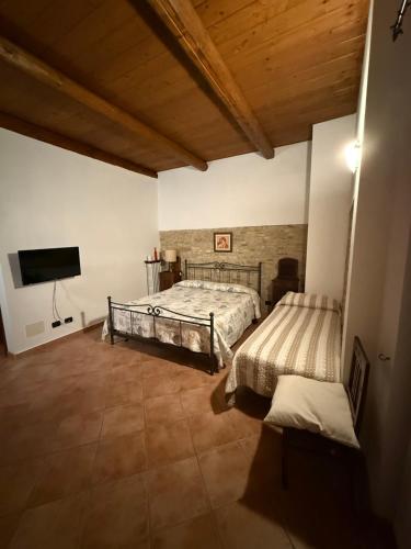 a bedroom with a bed and a flat screen tv at Cascina Filipot in Cerretto Langhe