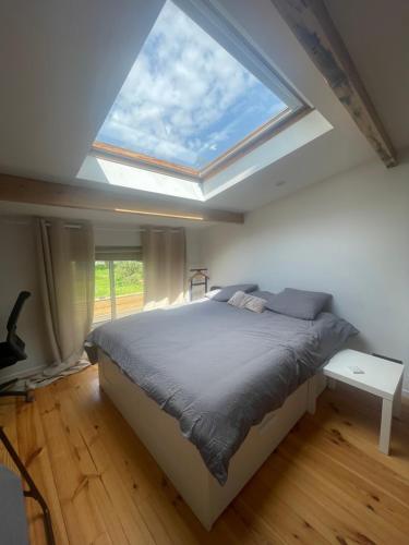 a bedroom with a large bed with a skylight at Olivia in Argenteuil