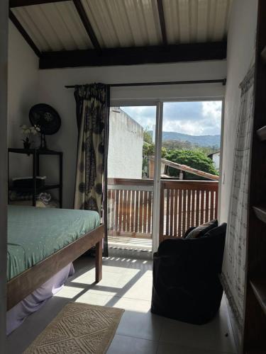 a bedroom with a balcony with a bed and a window at Floripa Beach House Hostel in Florianópolis